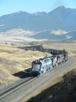 EMDX 9043 SD60 pulling a load up Bozeman Pass in front of Livi•gston Peak